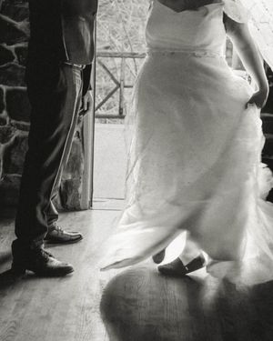 Black and white photo showing dress and suit details during a wedding dance.