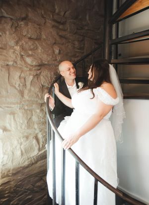 A tender moment shared on a stone staircase during a wedding celebration.