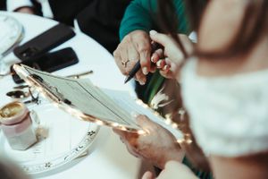Close-up of hands signing documents during a wedding ceremony.