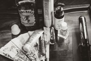 Black and white photo of wedding day preparation items including bottles and personal care products.