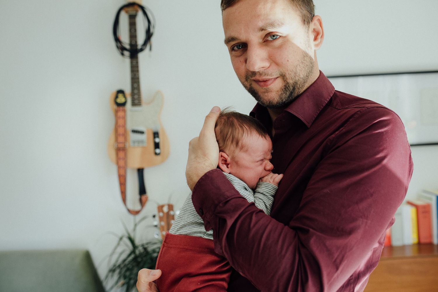 Vater umarmt sein neugeborenes Baby in den ersten Lebenswochen