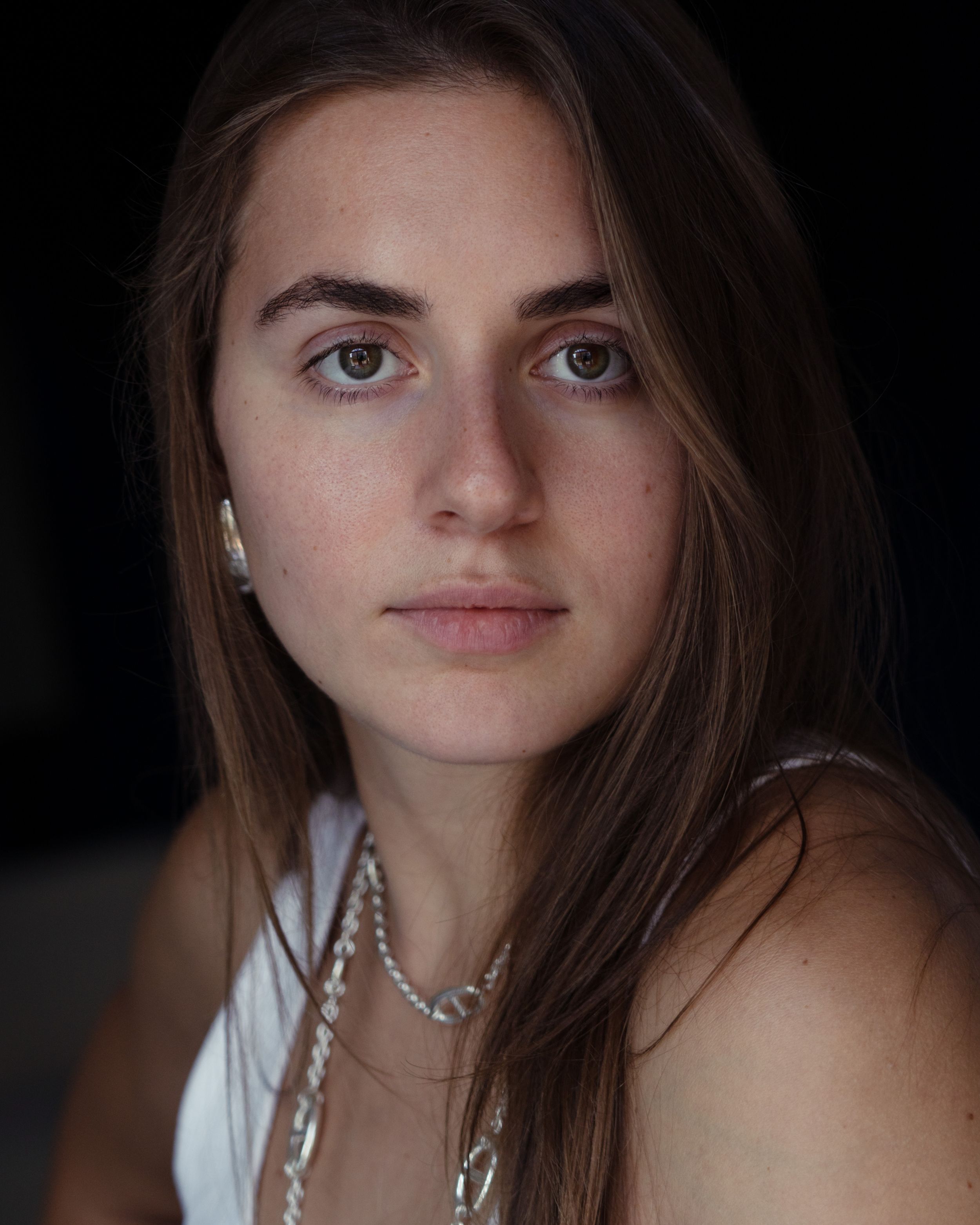 Close-up portrait of a woman illuminated by natural light.