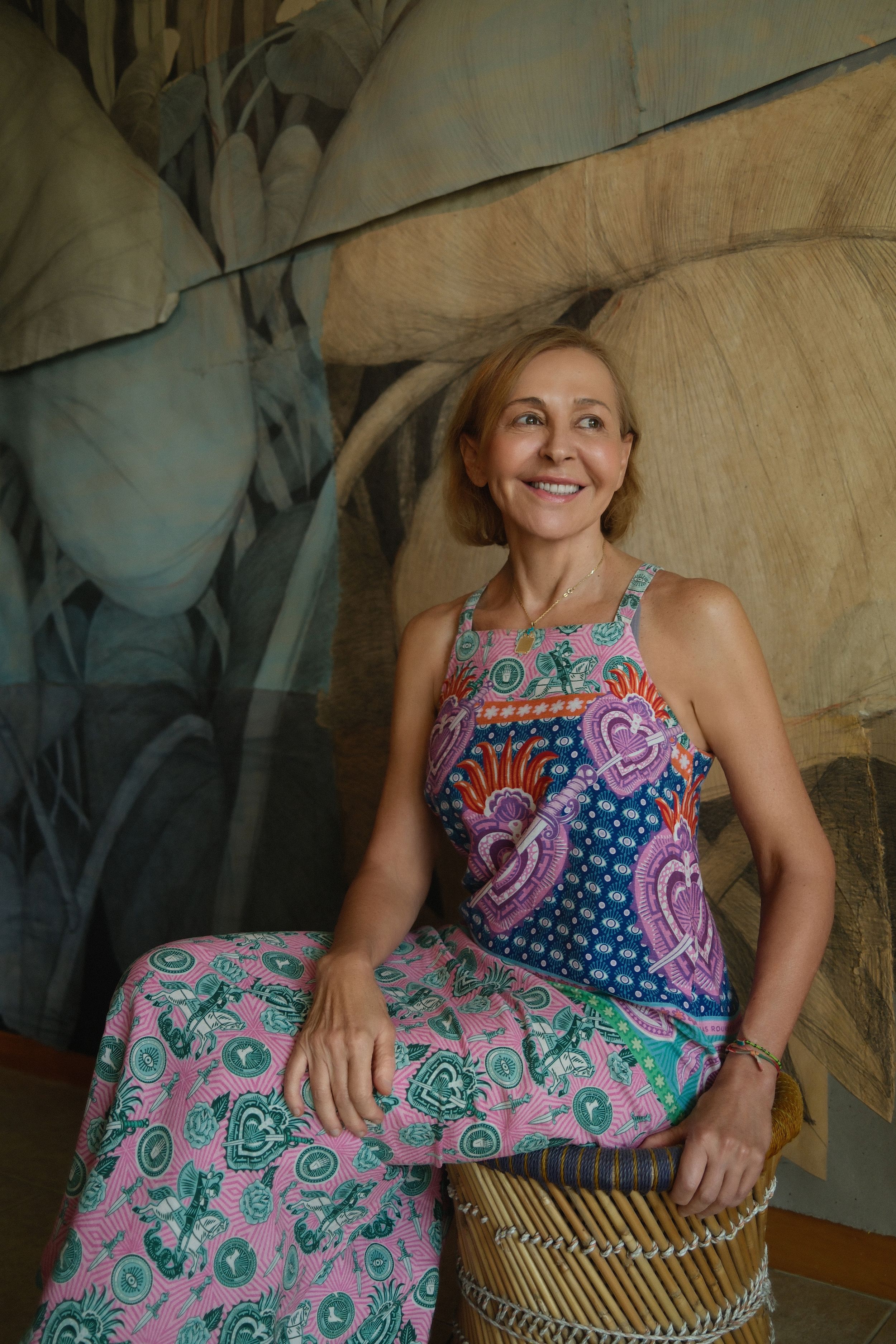 Portrait of a female artist Elizabeth Dorazio in natural light with artwork displayed in the background.