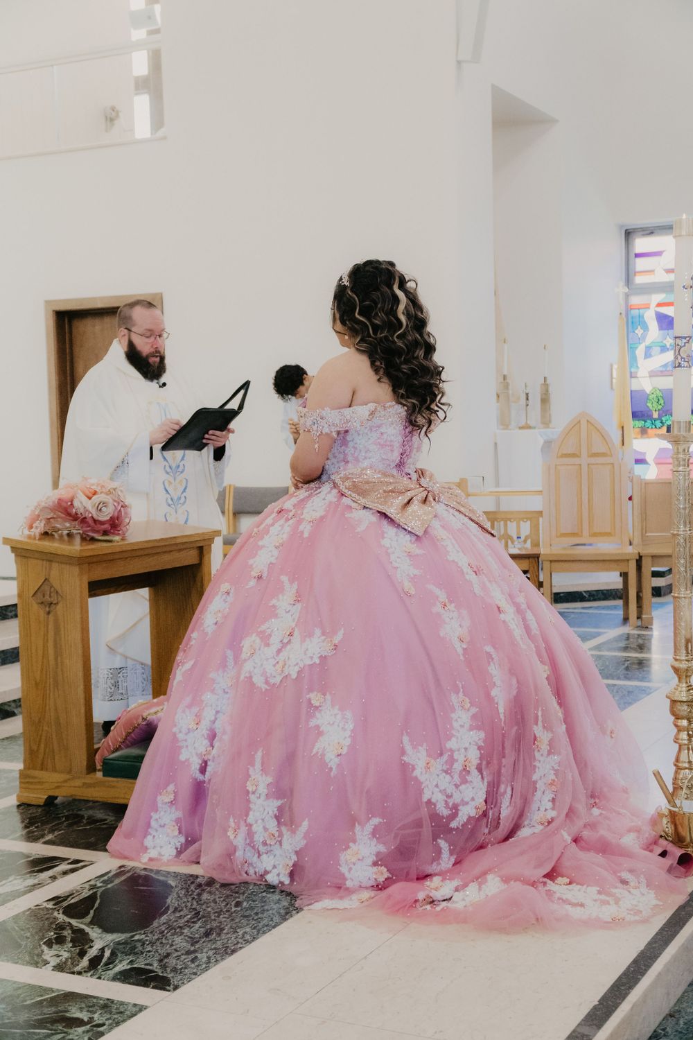 Quinceañera receiving blessing from priest, East Tennessee