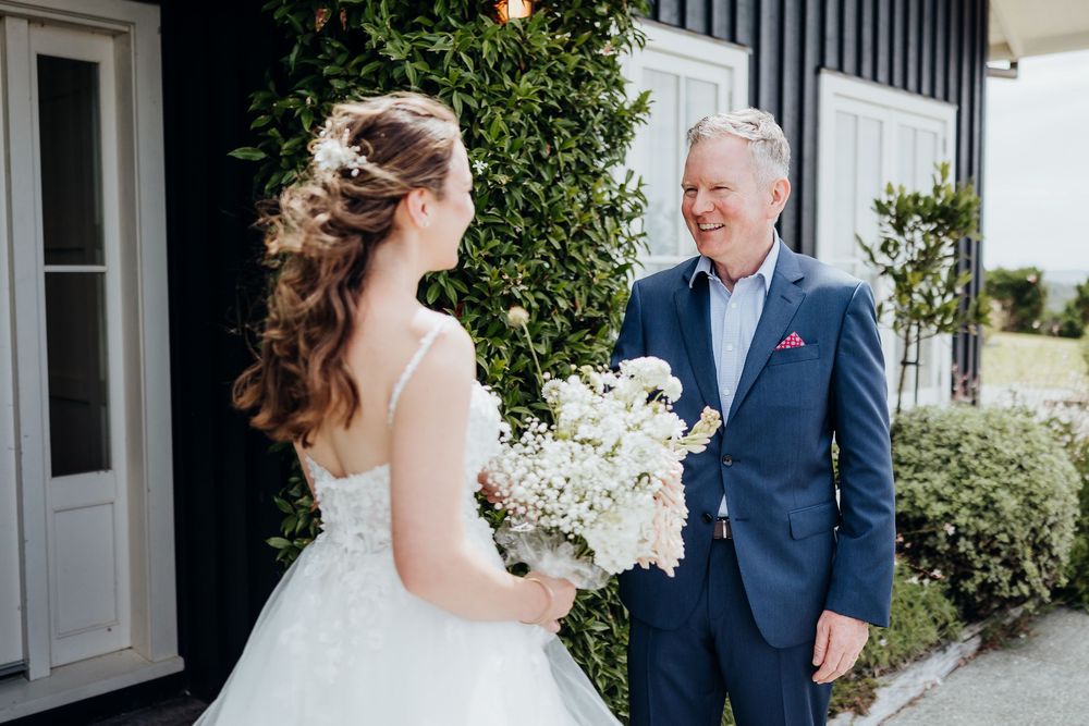 A joyful wedding moment captured outside a modern white and black building.
