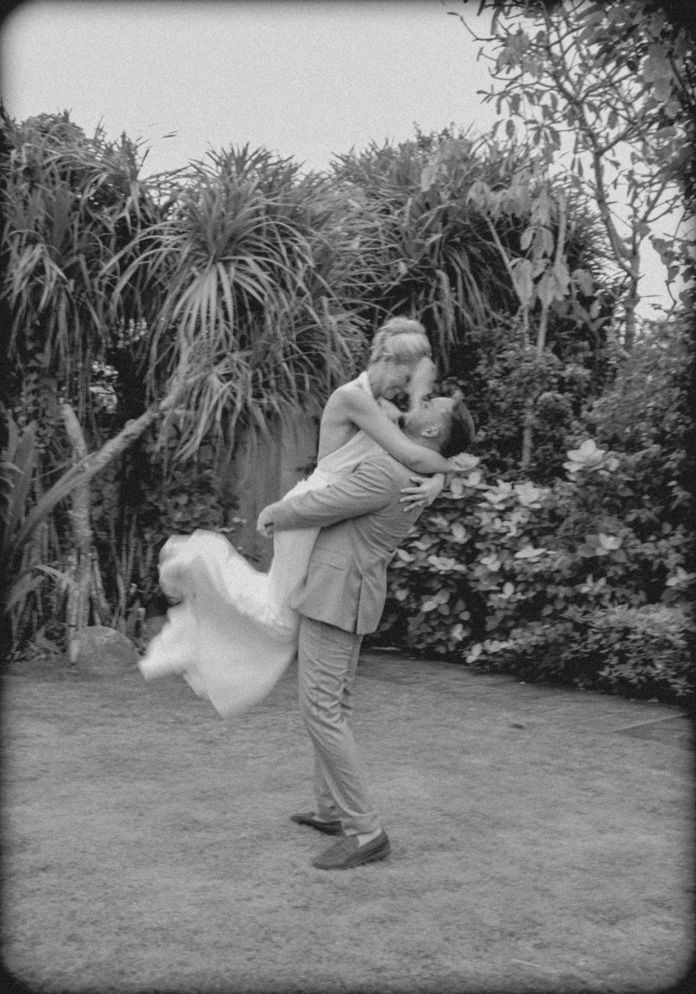 A sequence of black and white photos shows a couple performing a dance lift in a garden setting.