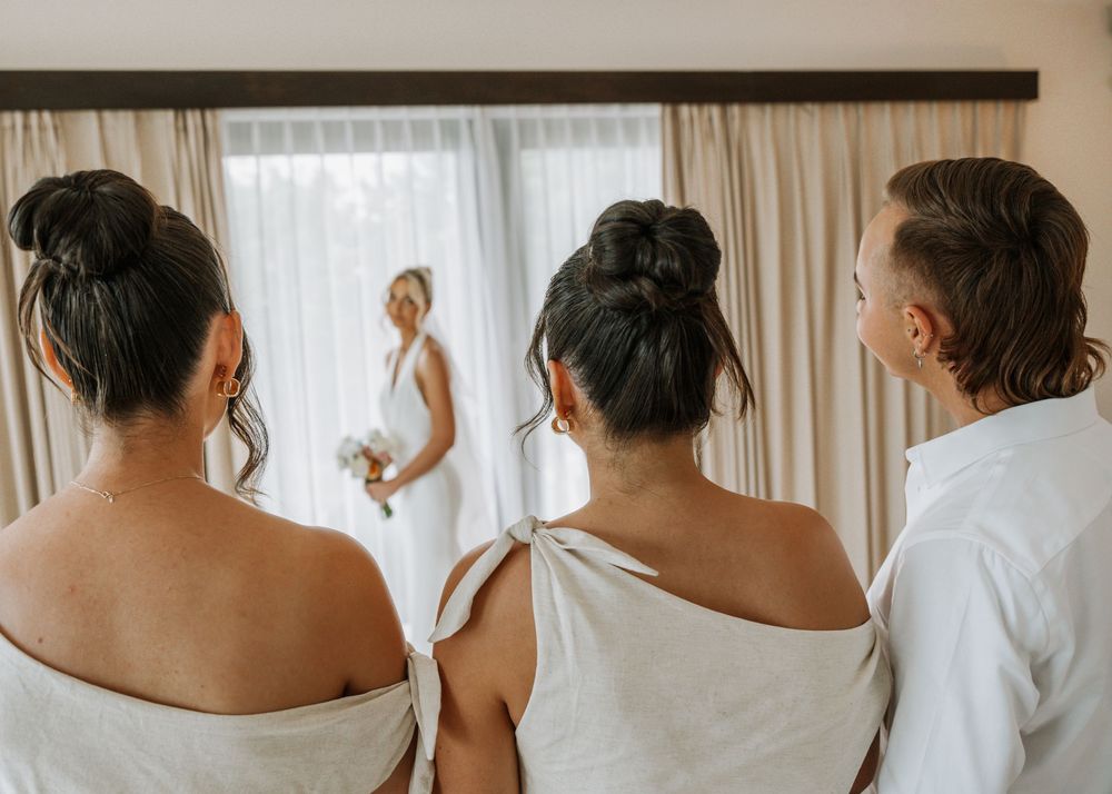 Close-up view of bridesmaids wearing white robes while getting ready for wedding day.