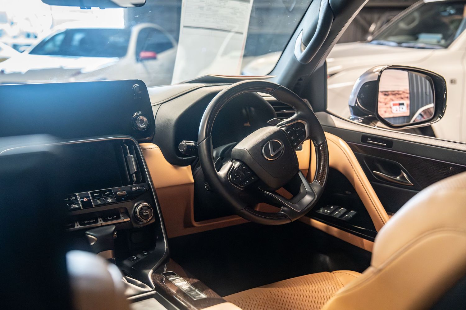 A luxurious car interior with beige leather seats and a modern black dashboard showcases premium automotive design.