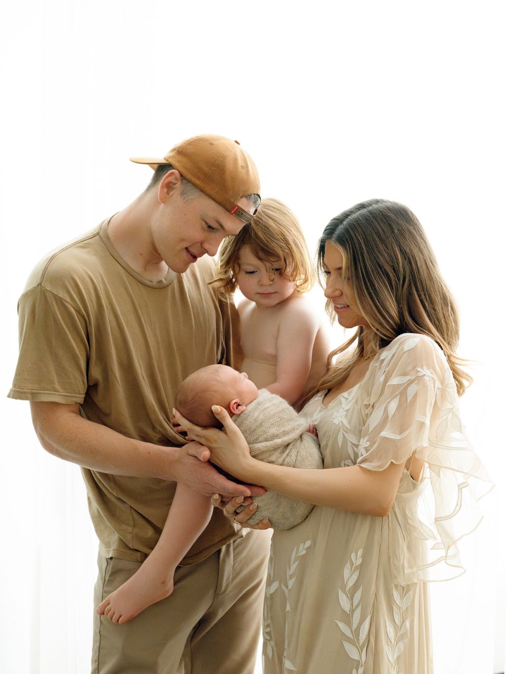 A peaceful and serene family portrait series in neutral beige and cream tones showing intimate moments together.