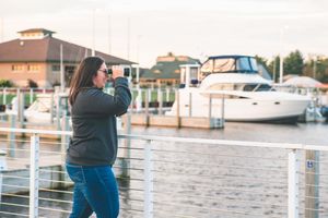 woman looks out over marina with binoculars