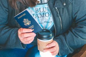 travel agent detail photo of coffee, passport, and branded shirt