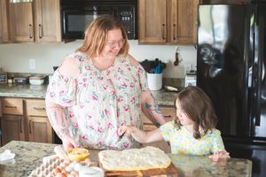 Mother and daughter bake cinnamon rolls in a kitchen