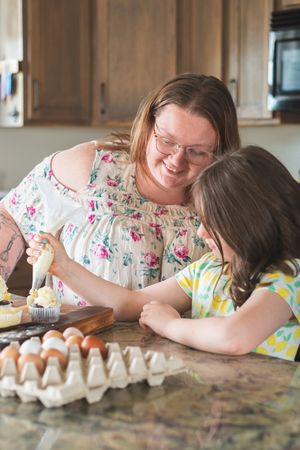 Mother and daughter bake cupcakes in a kitchen