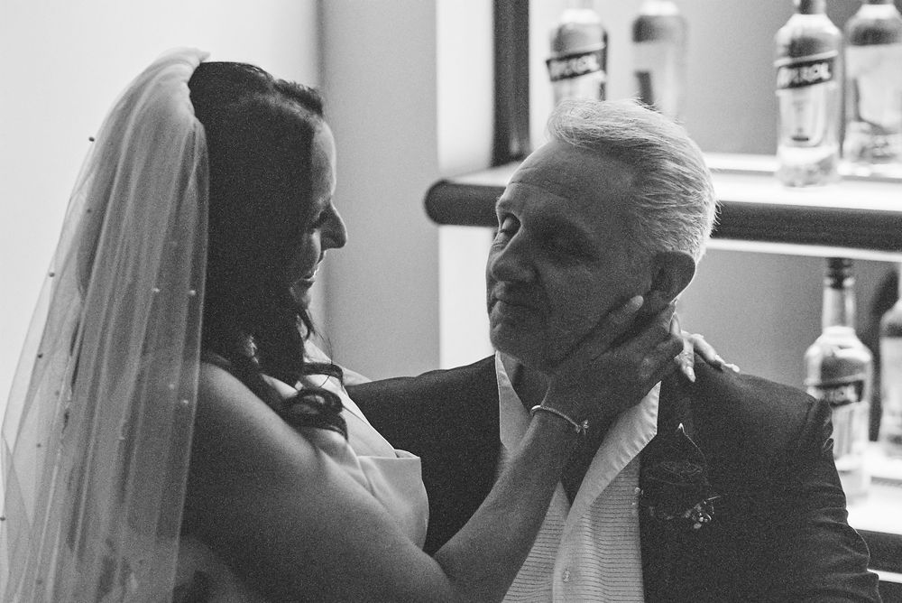 A touching black and white moment between two people on what appears to be a wedding day.