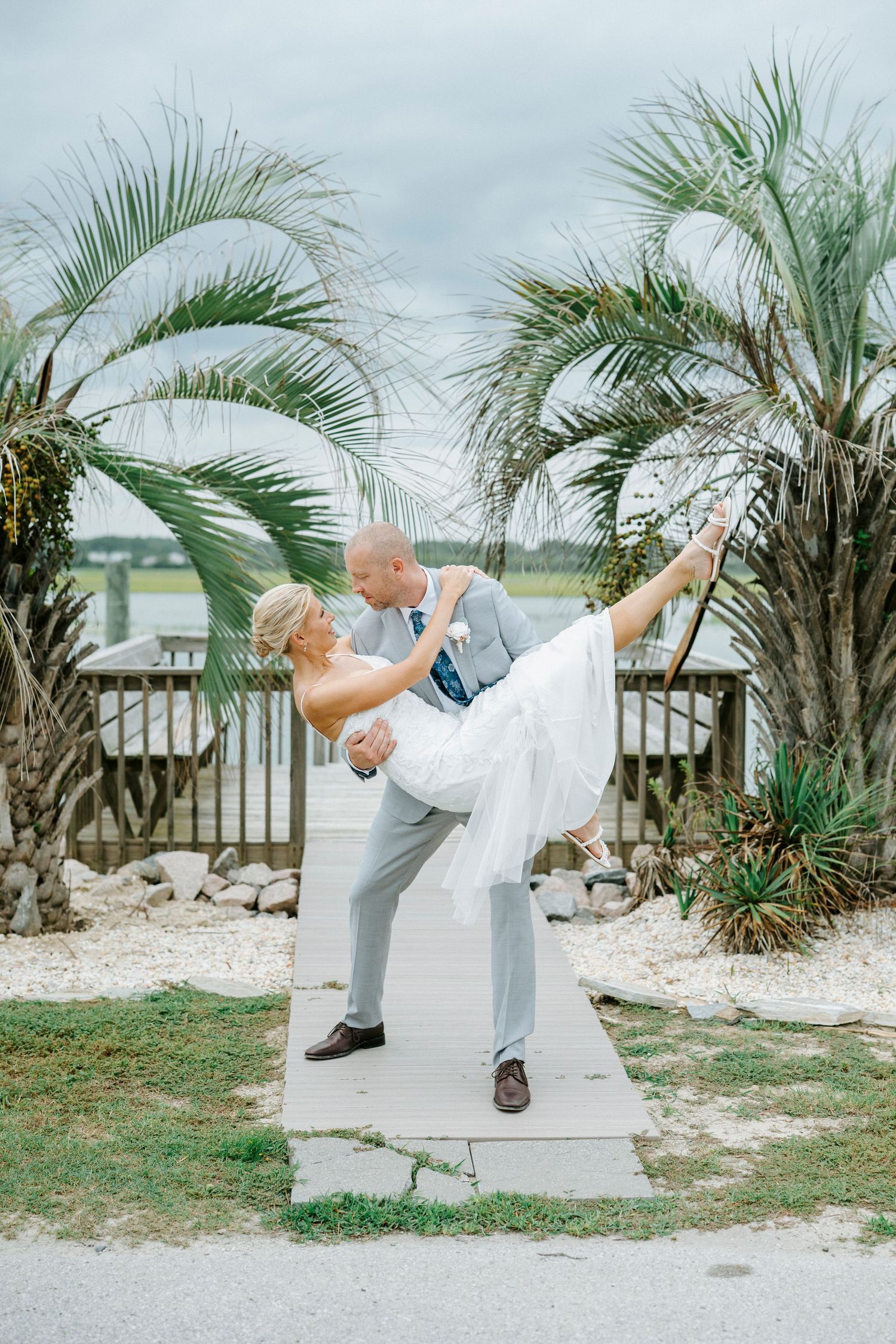 Four sequential photos show a couple doing kung-fu style moves and poses on a beach boardwalk with palm trees.