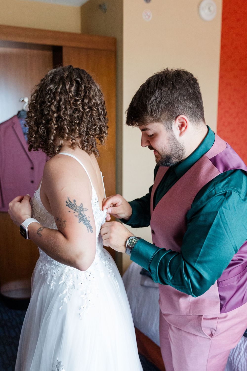 A sequence showing a dress being zipped up in a room with red walls and a mirrored wardrobe.