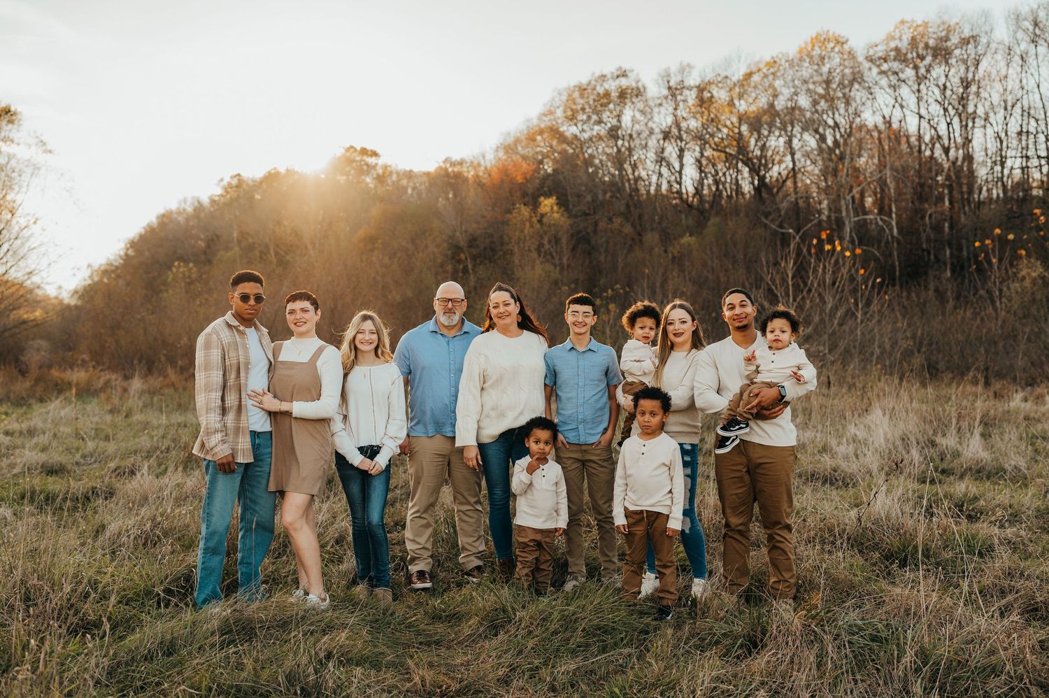 A group poses together in casual attire against a natural outdoor setting during golden hour sunset mchenry county Il