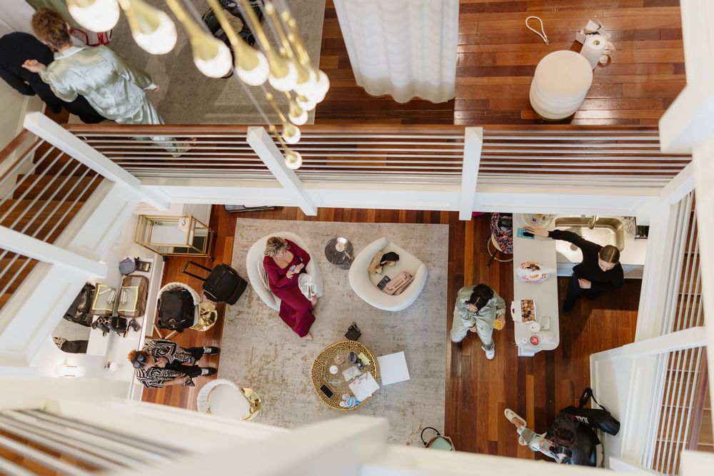 Overhead view of wedding reception setup with wooden tables and hanging lights from multiple angles.
