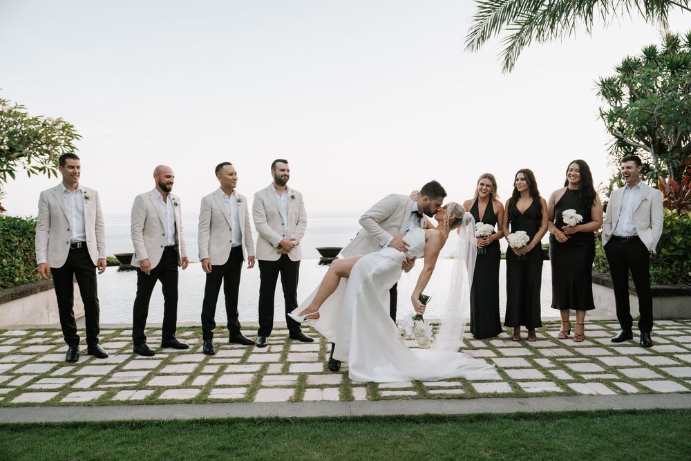 Wedding party poses outdoors in sequence at mountaintop venue with lush greenery and scenic landscape views.