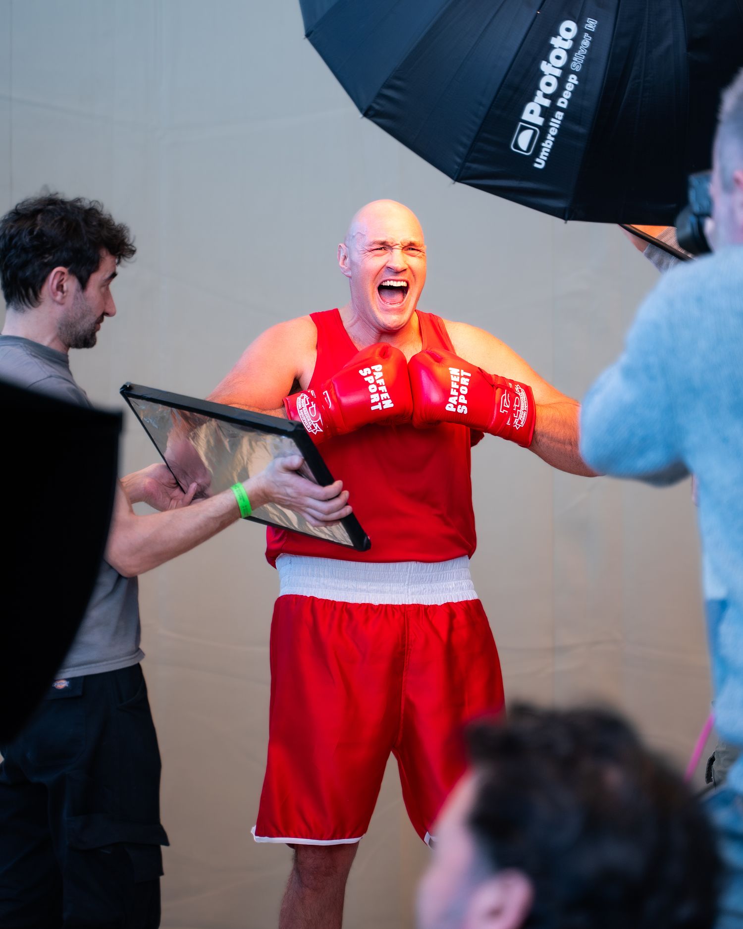 A series of four photos showing someone in a red outfit being photographed during what appears to be a studio photoshoot.