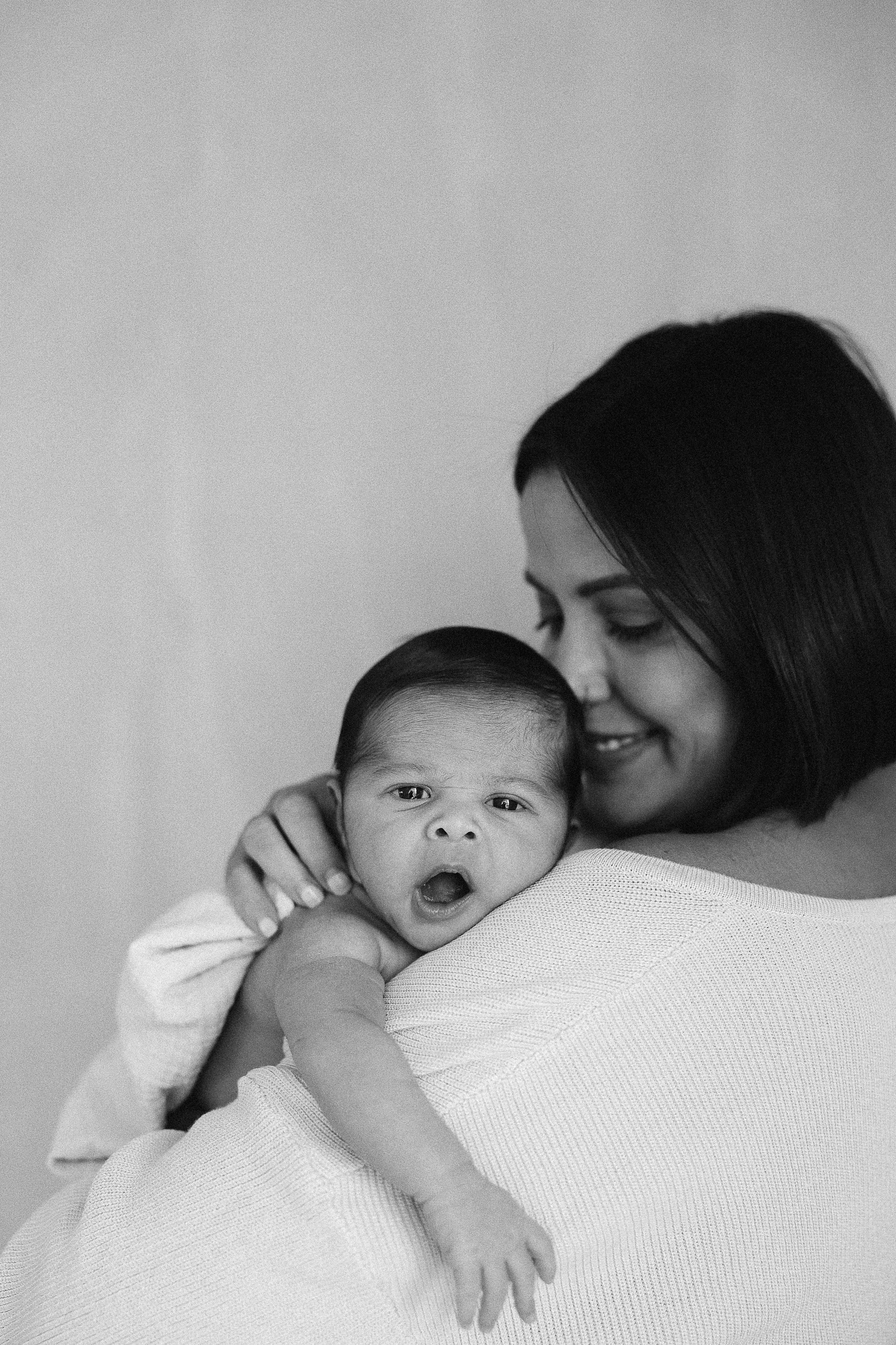 Newborn baby wrapped in neutral swaddle during photoshoot at Spark Studios
