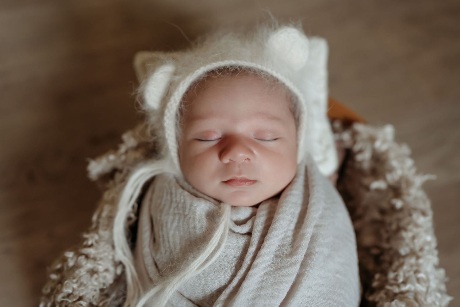 Six delicate black and white close-up newborn portraits in natural light with soft textures and knit accessories.