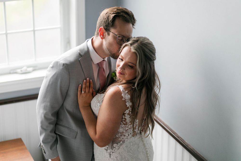 A couple shares an intimate moment during their wedding photo session in a bright, modern space.