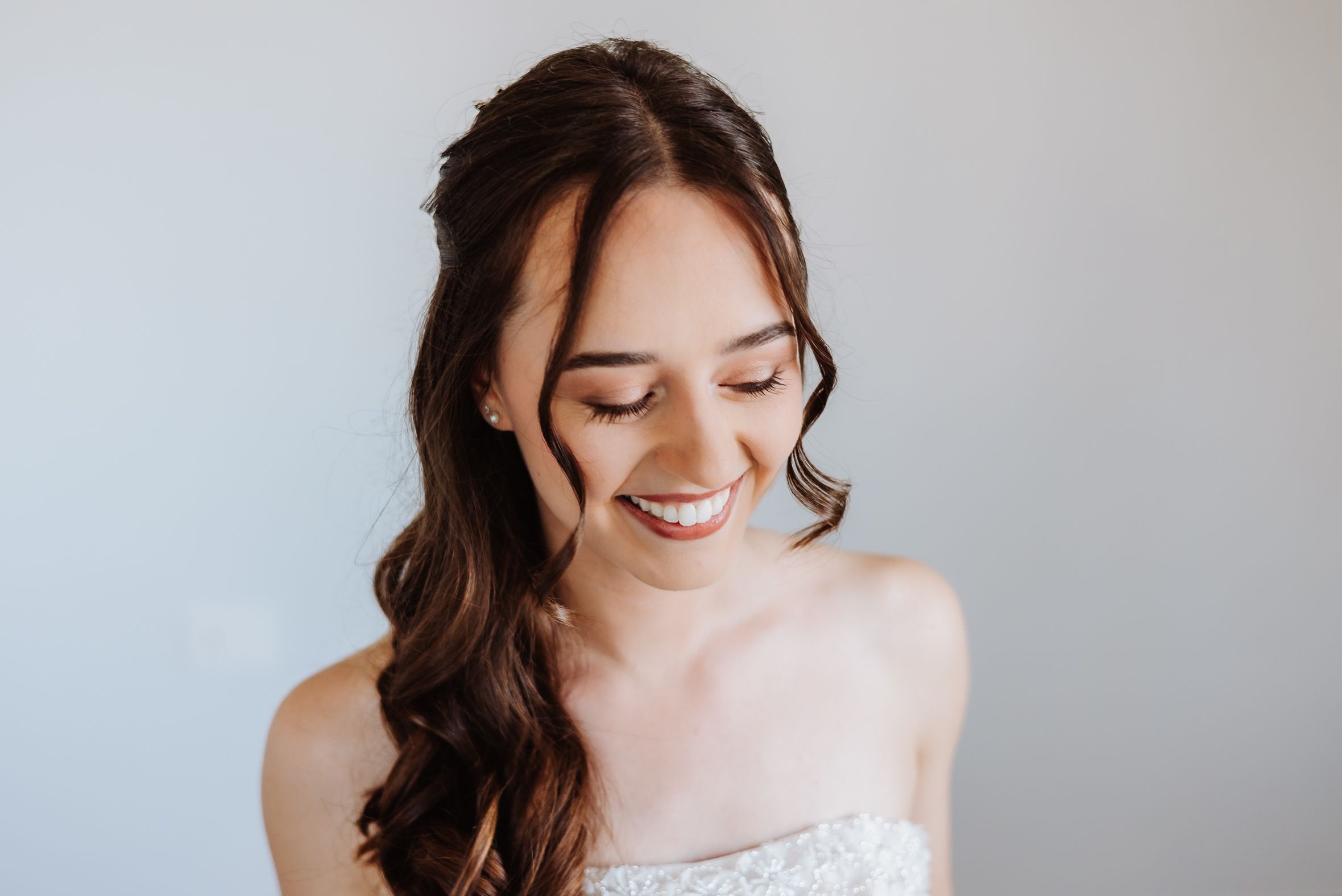 A bridal photoshoot series showing natural, romantic poses with flowing brunette hair and a white wedding dress.