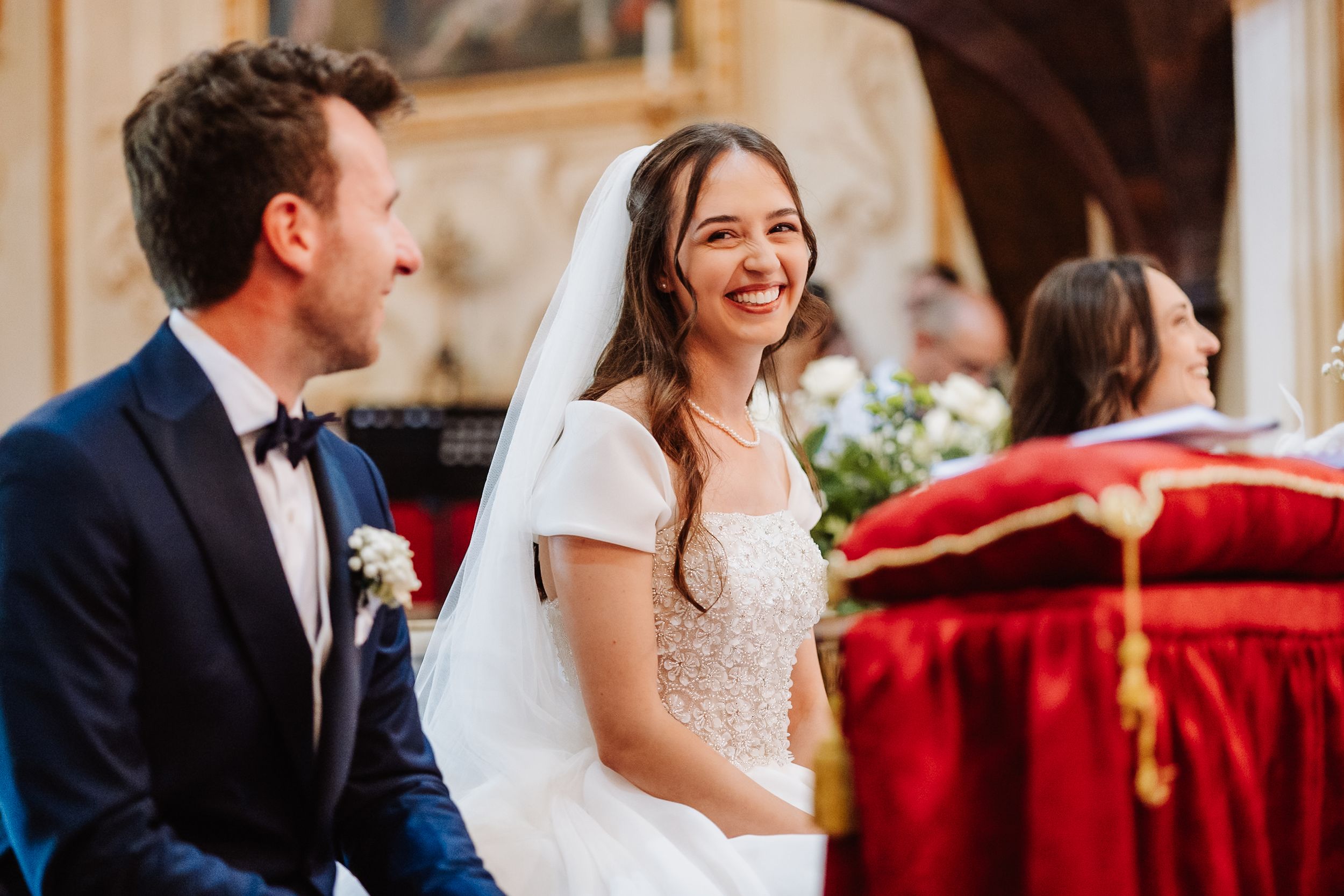Happy couple sharing joyful laughter during an elegant wedding reception in a beautiful venue.