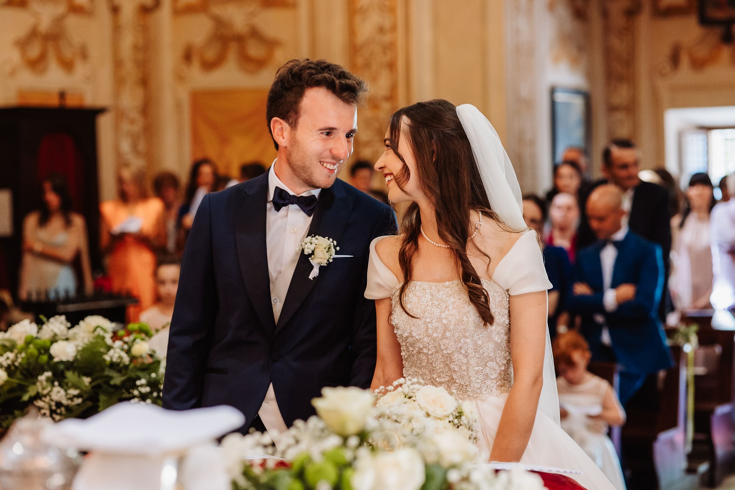 A romantic atmosphere fills an elegant wedding reception venue as a couple shares a loving moment together at their table.