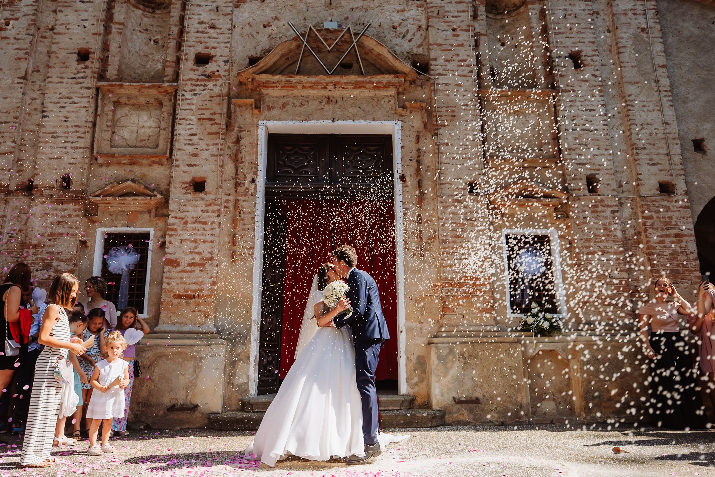 A series of six connected wedding photos showing confetti moments and celebrations outside a rustic stone church.