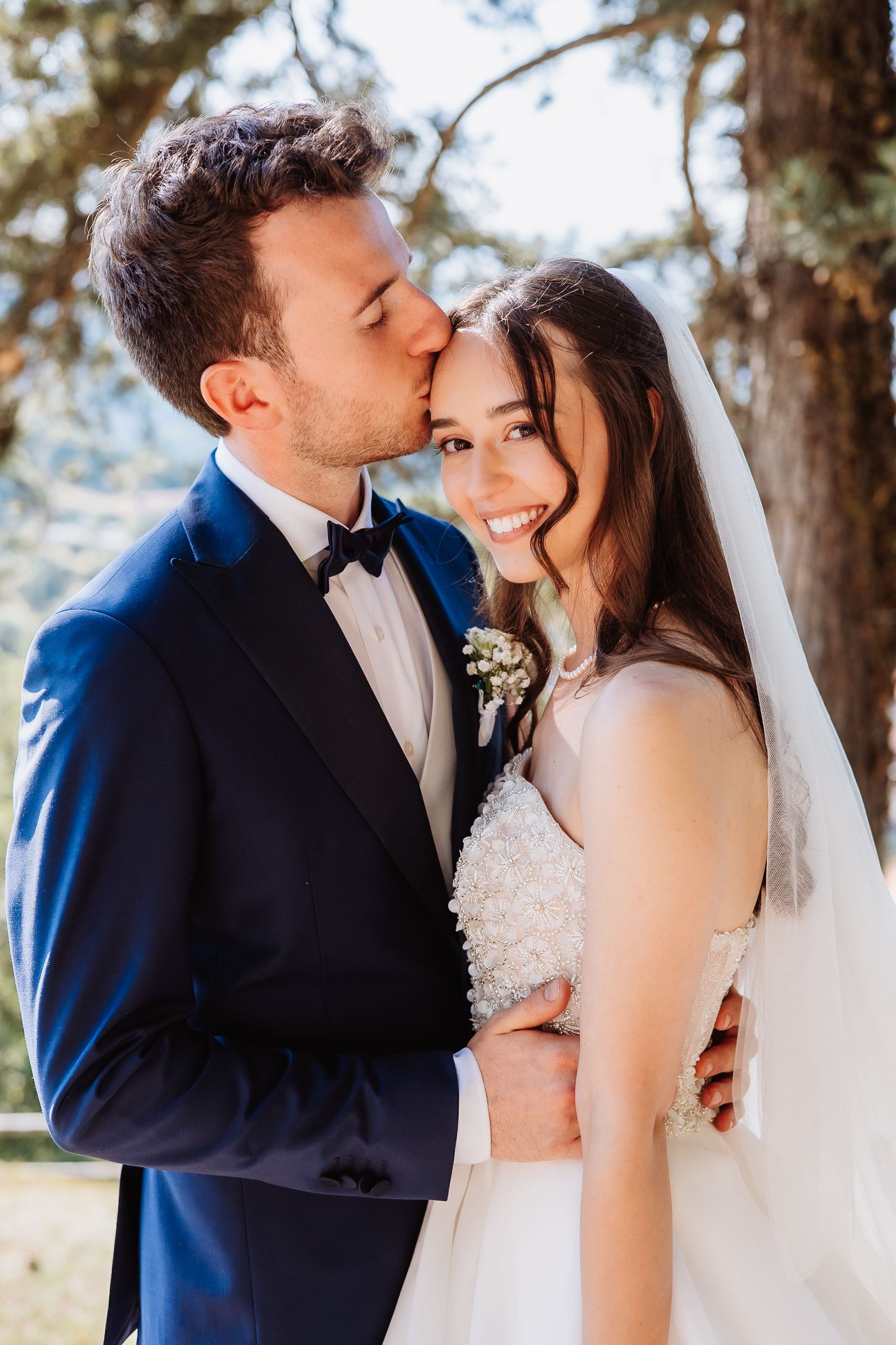 A romantic wedding couple shares intimate kisses in a series of four outdoor portraits against a natural backdrop.