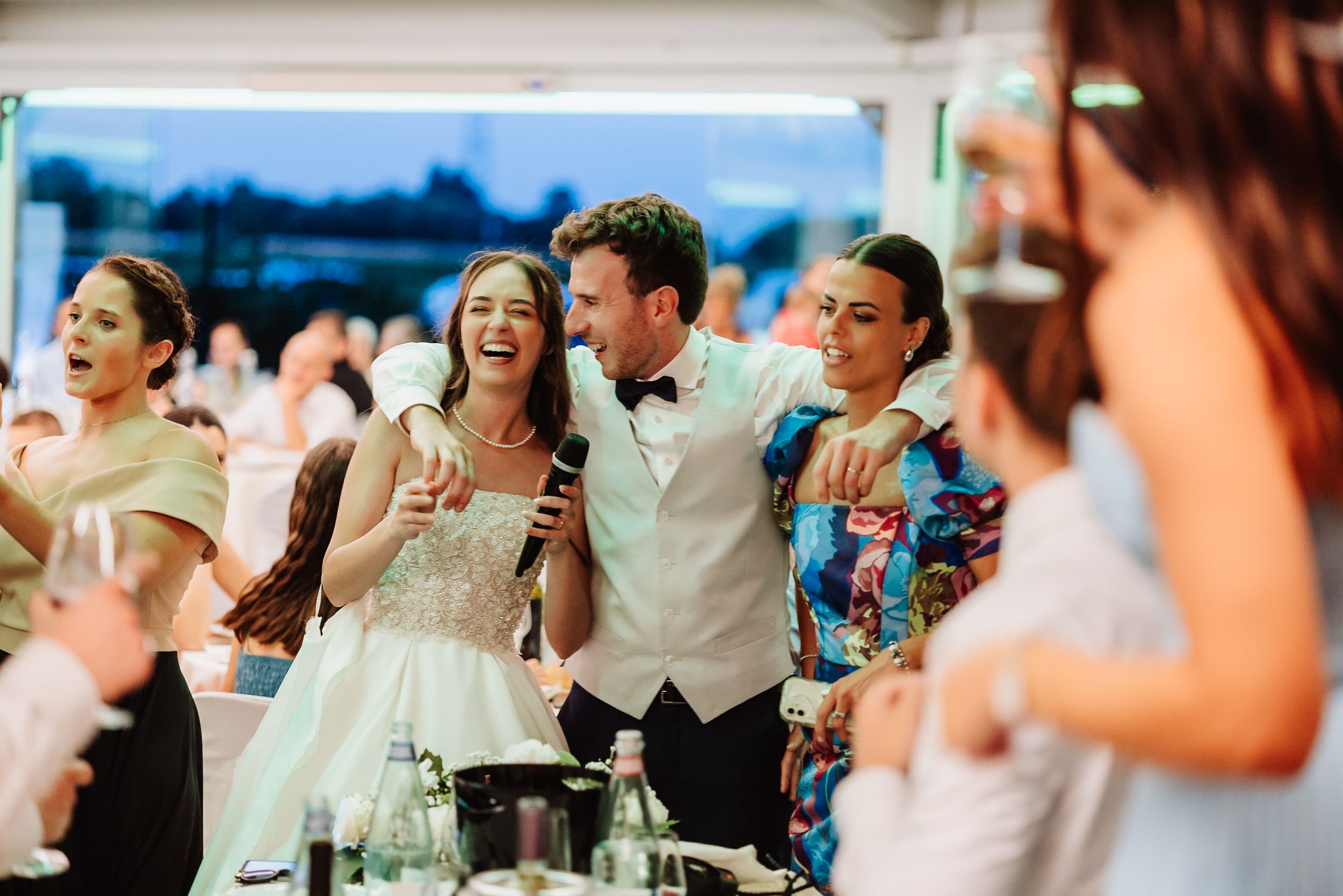 Wedding guests laughing and enjoying themselves during a reception celebration at a venue.