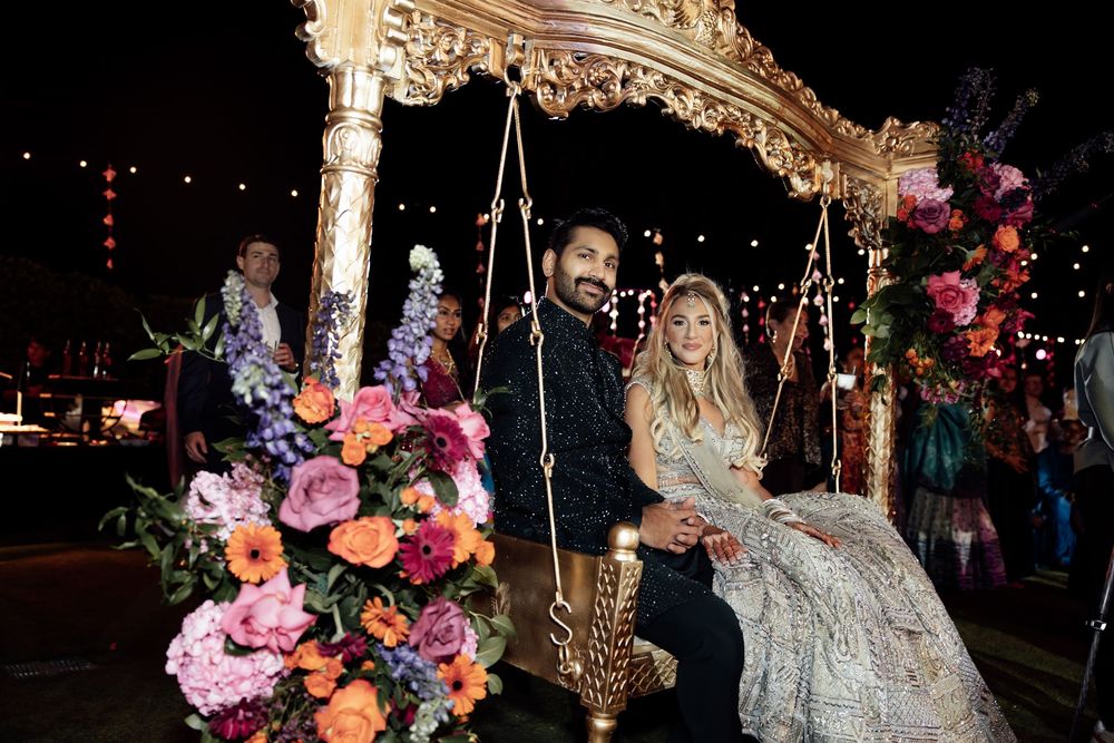 Ornate wedding reception venue decorated with hanging floral arrangements and dramatic lighting.
