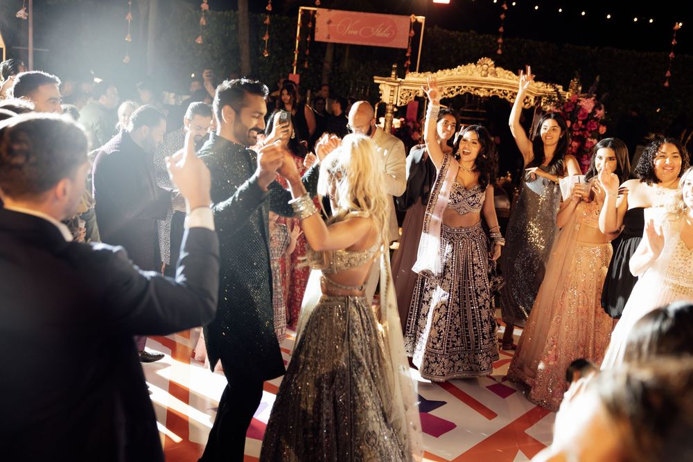 Wedding reception dance party with festive lighting and guests celebrating on the dance floor.