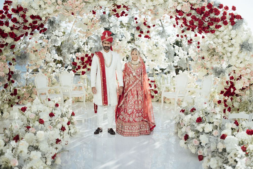 Decorative floral wall installation featuring white flowers and burgundy accents for a wedding backdrop.