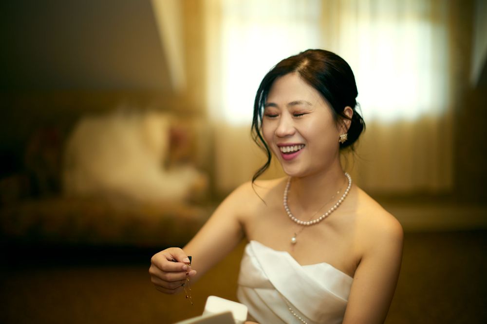 A bride in a white strapless wedding dress smiles while sitting during a wedding reception celebration. at VIVO RESTAURANT