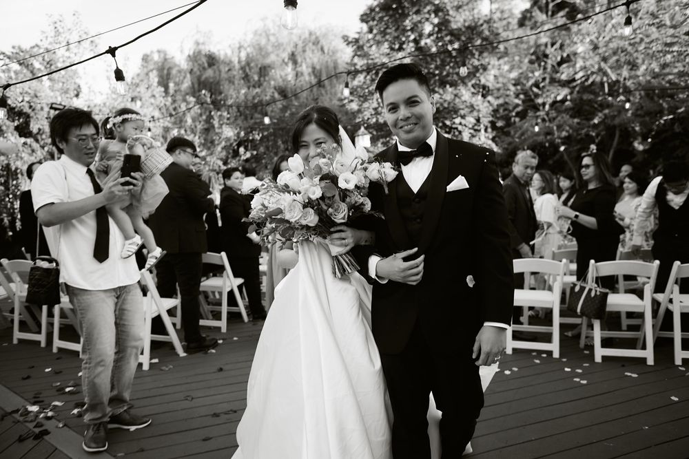 A couple shares a dance at an outdoor wedding celebration surrounded by guests and white chairs. at VIVO RESTAURANT