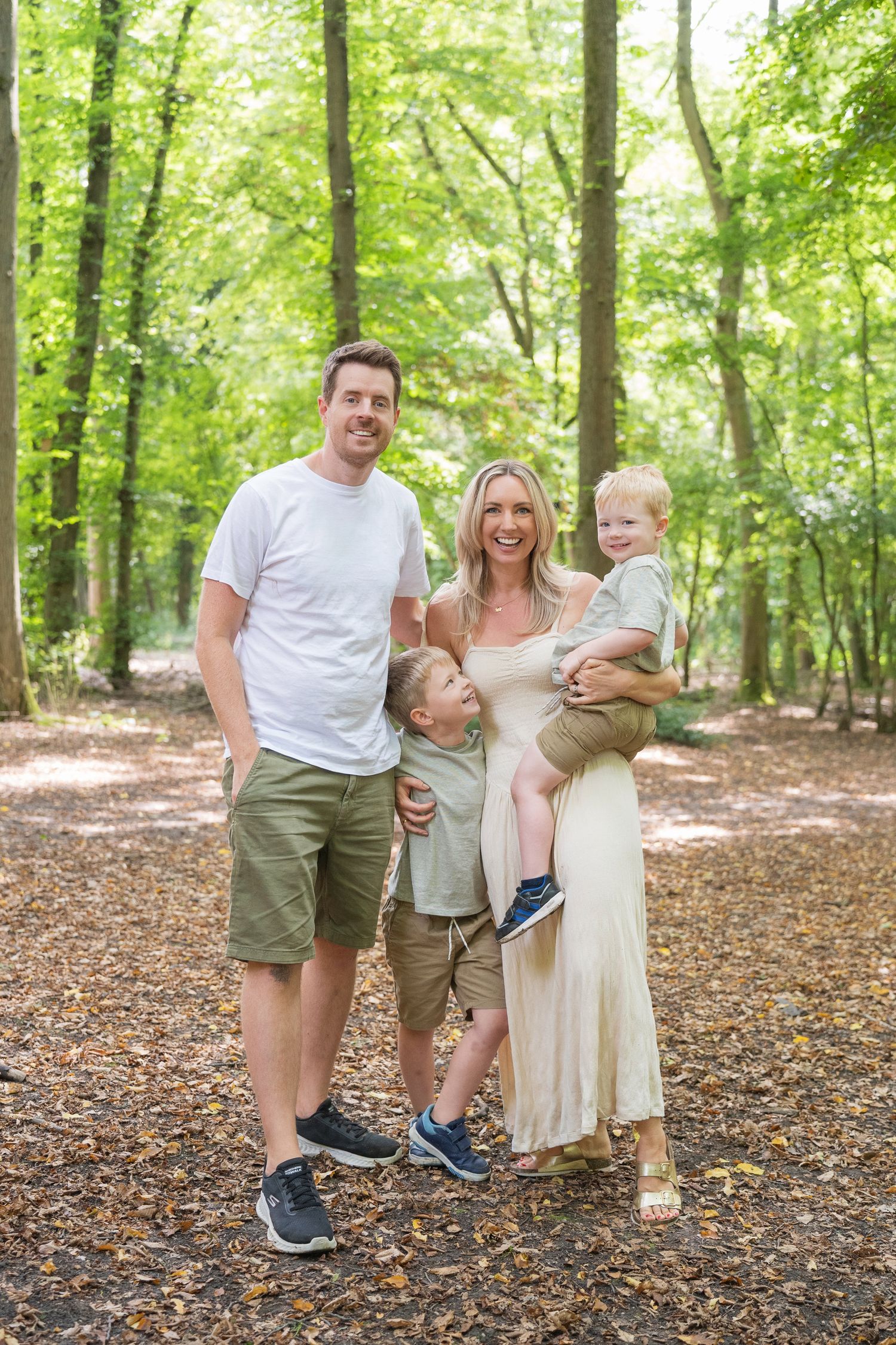 A casual outdoor family sitting arrangement where multiple photos are joined showing them relaxed on a fallen tree log.