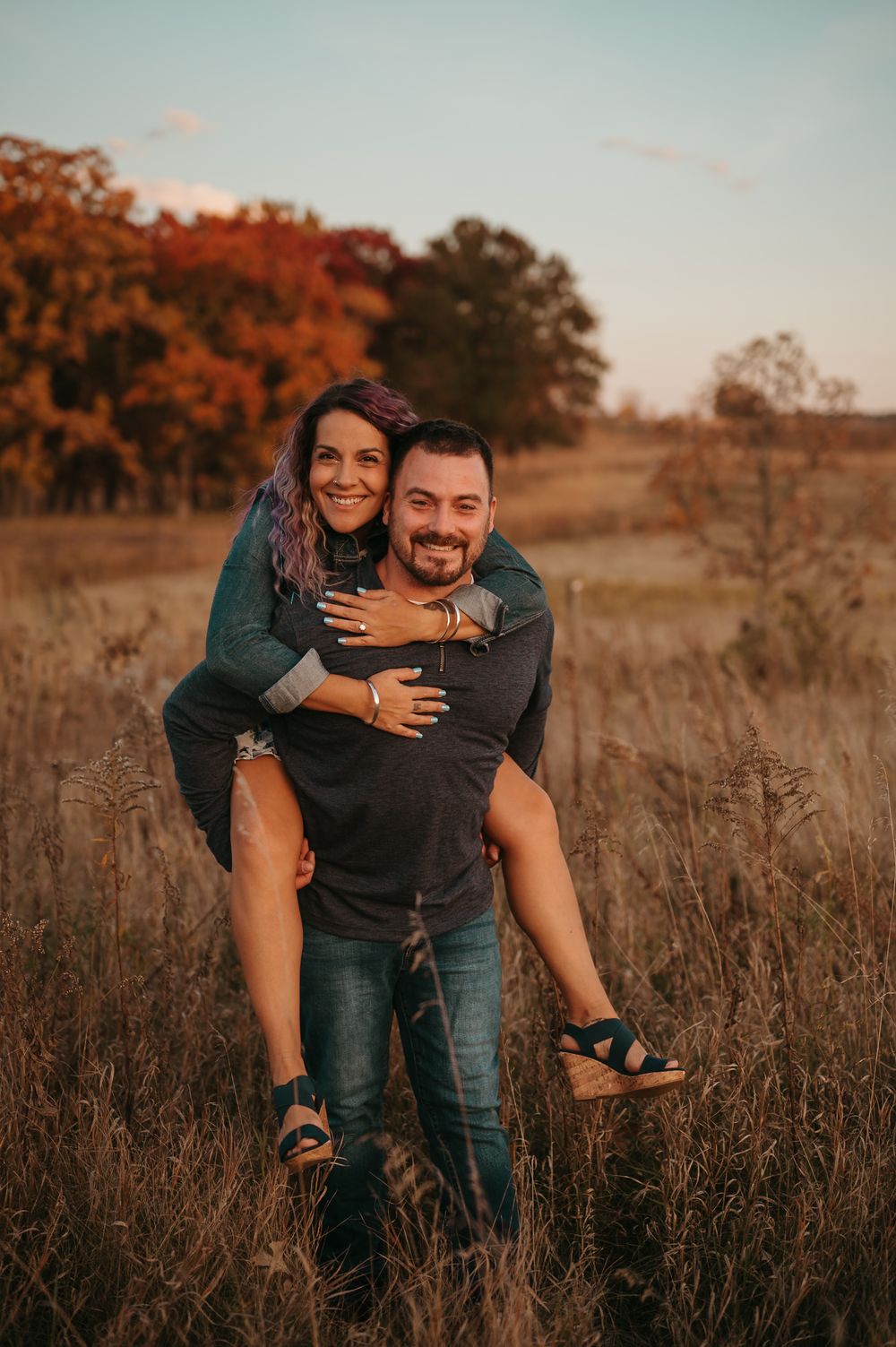 A playful piggyback ride moment captured in a golden autumn field during sunset.