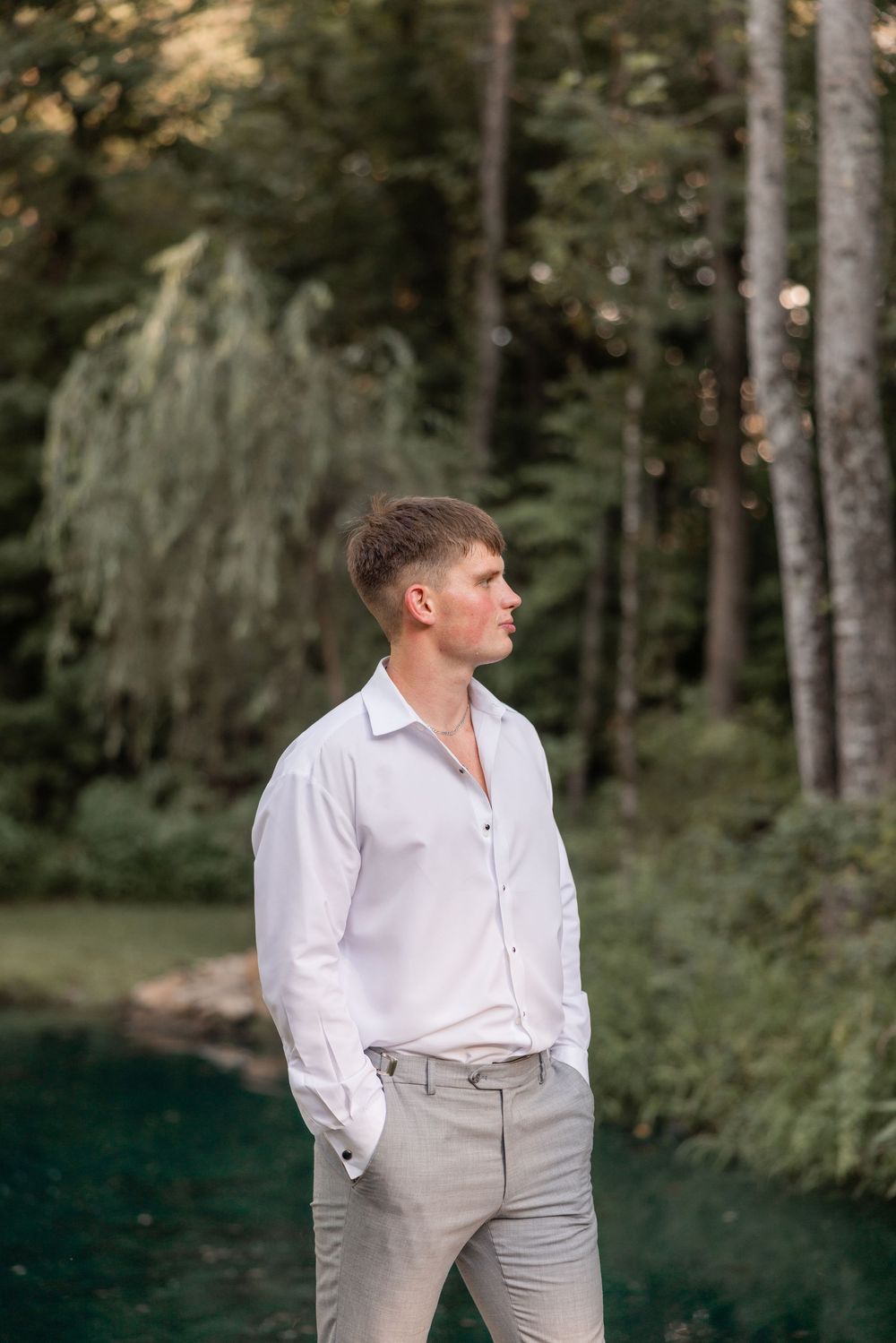 A series of four similar portraits showing a person in a white shirt and light pants standing in a wooded outdoor setting.