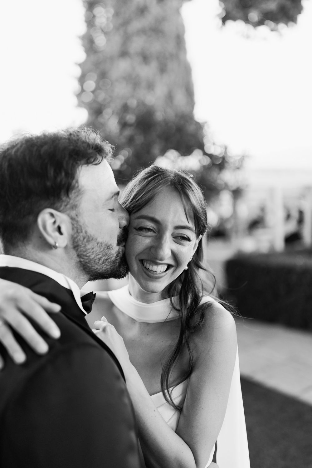 Close up tender moment between newlyweds outdoors in black and white photography.