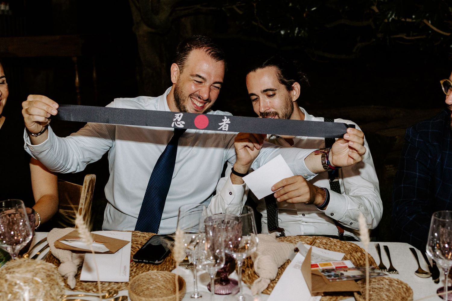 Wedding reception dinner scene with guests dining at decorated tables.