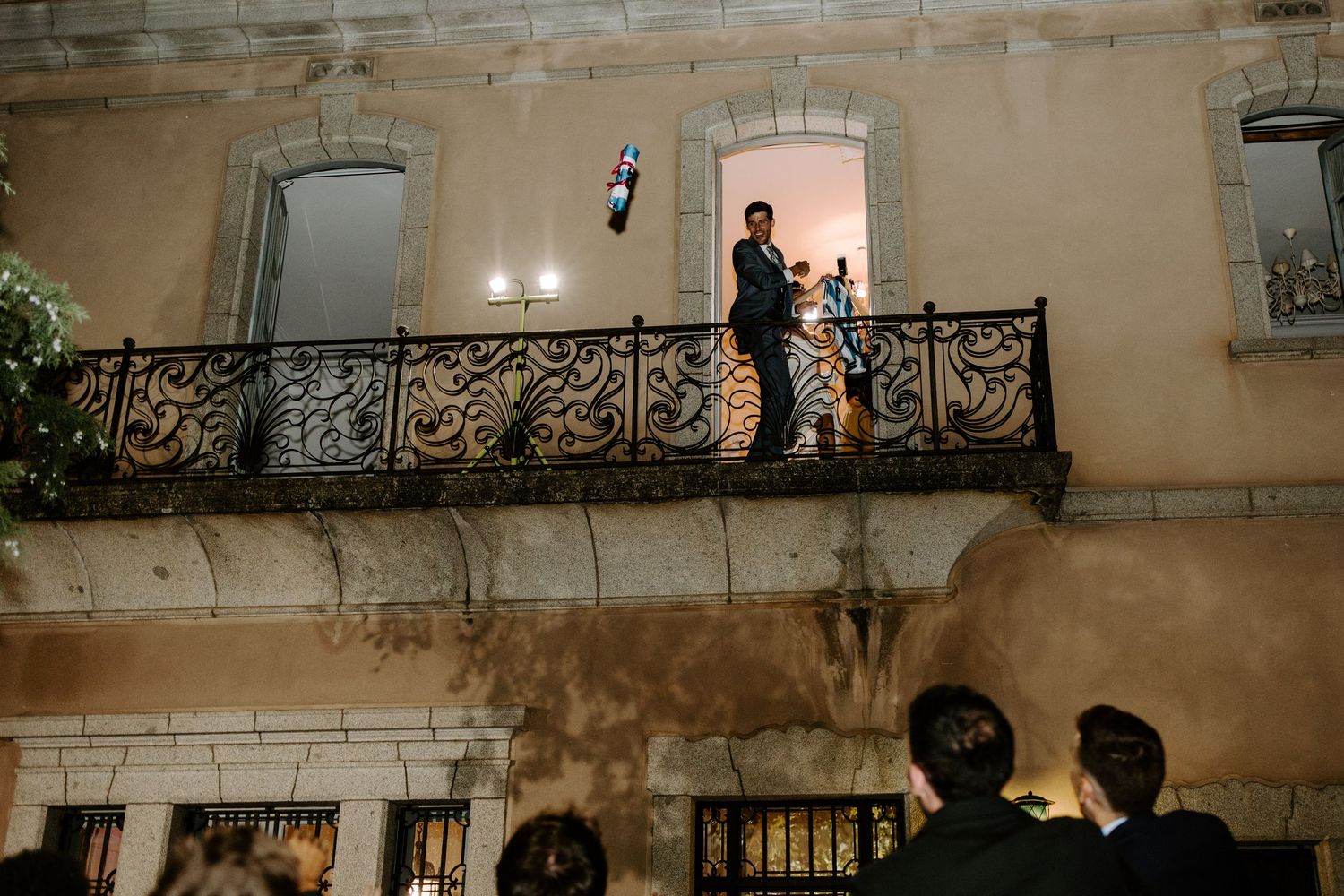 Aerial view of wedding guests mingling in an elegant courtyard with stone architecture.