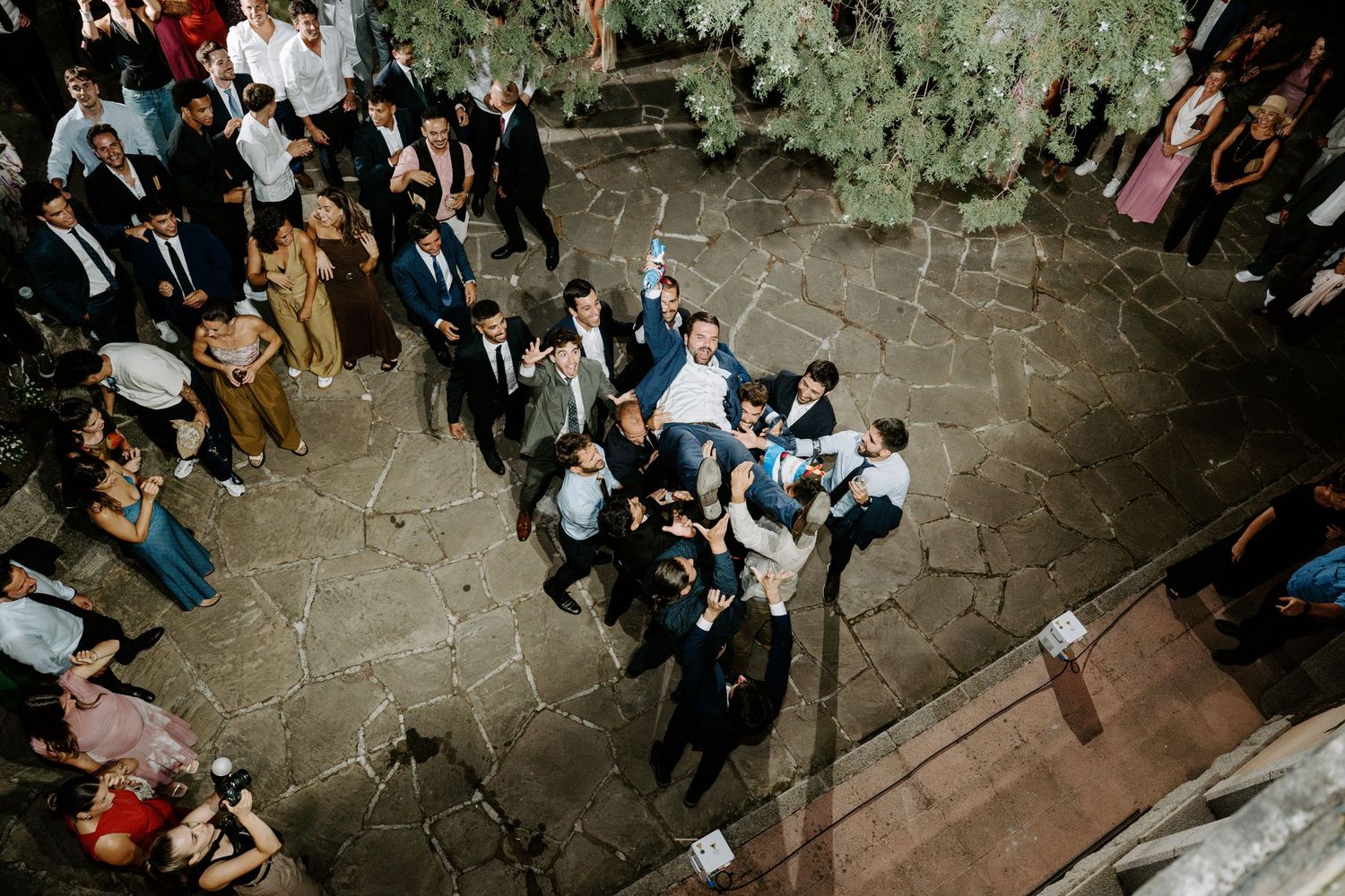 A couple shares their first dance surrounded by string lights in an elegant venue.
