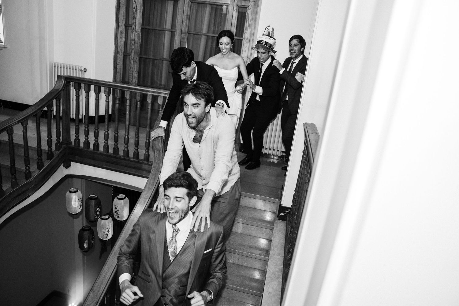 Black and white photo of guests enjoying themselves during a lively wedding reception.