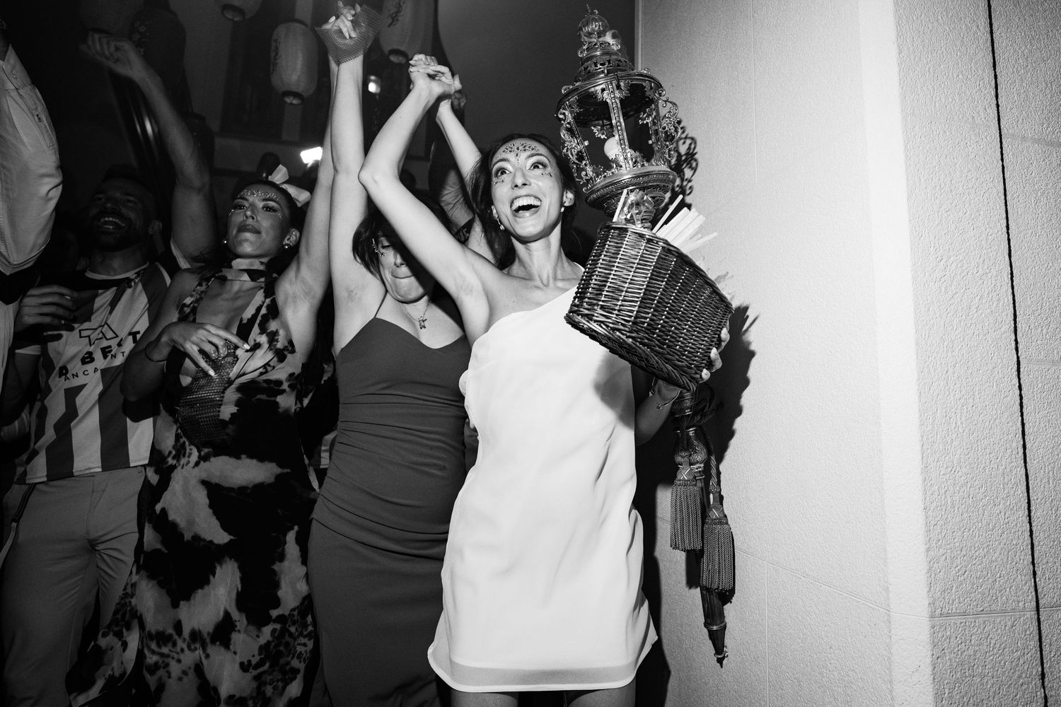 Party guests celebrating with joyful expressions in a dimly lit venue.