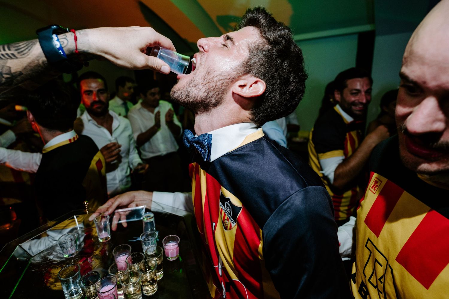 Celebratory moment at a party with red and yellow striped flags being waved.