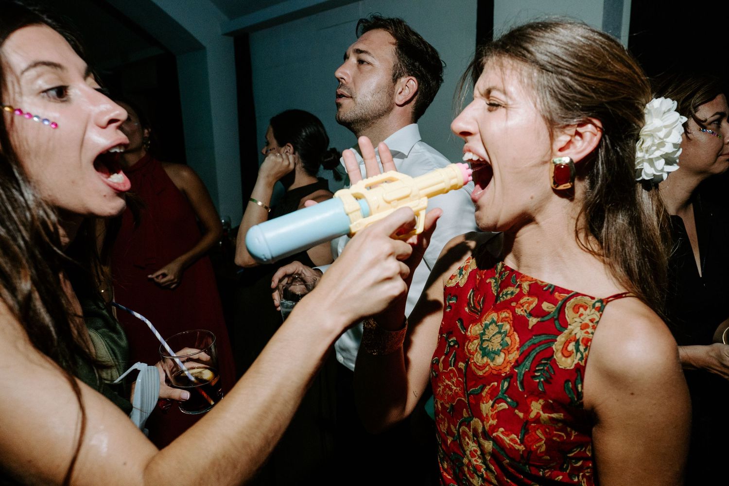 Party guests enthusiastically sing karaoke together at a lively celebration.