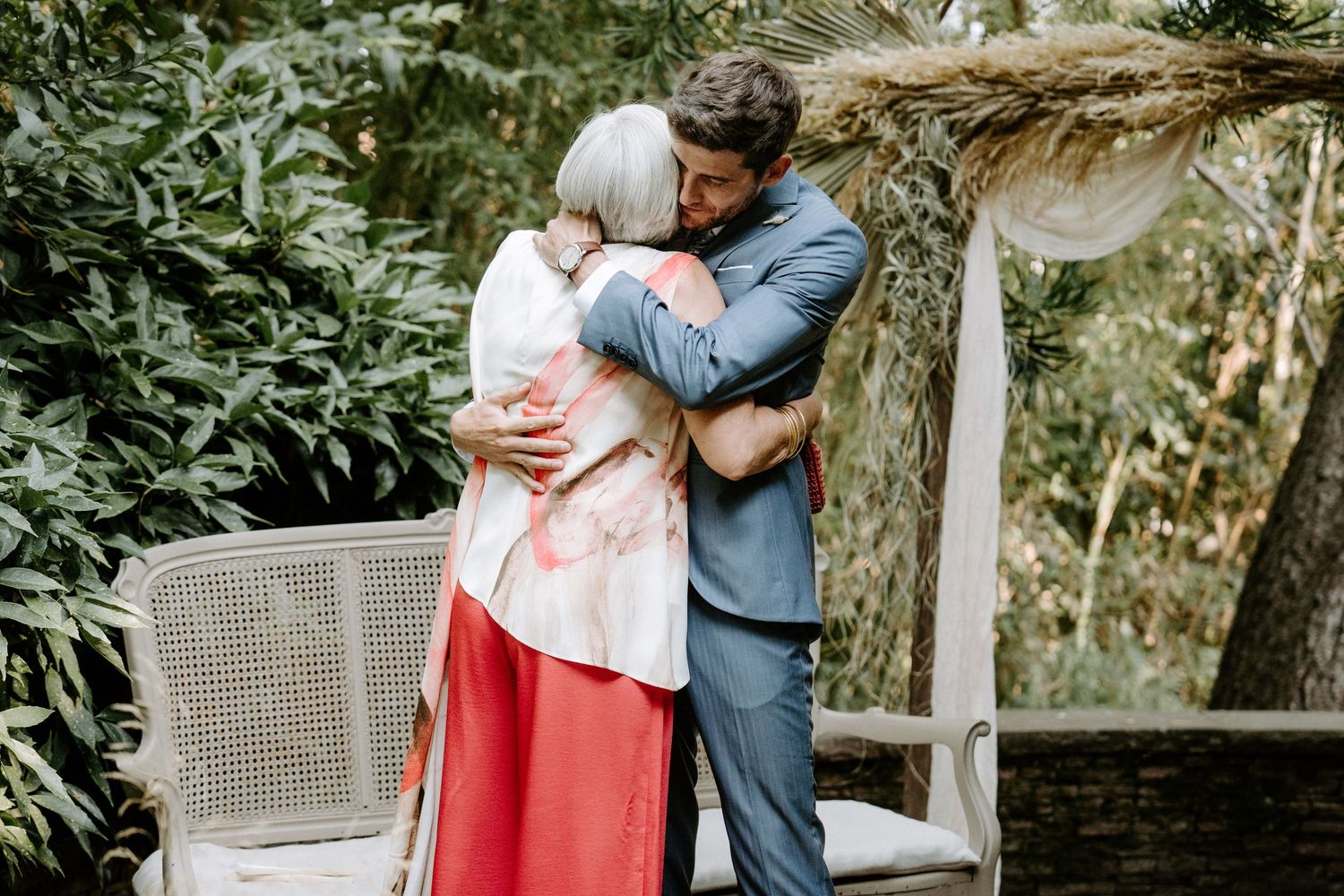 An intimate moment captured in a garden setting with rustic arch decor.